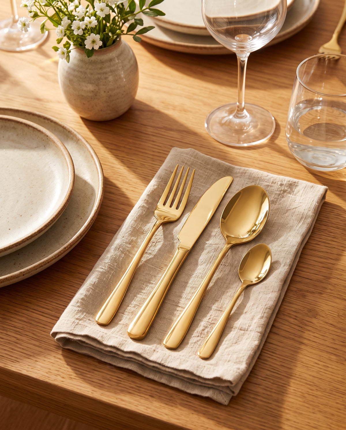 24-piece gold stainless steel cutlery set, fork knife spoon and teaspoon on a dinner table